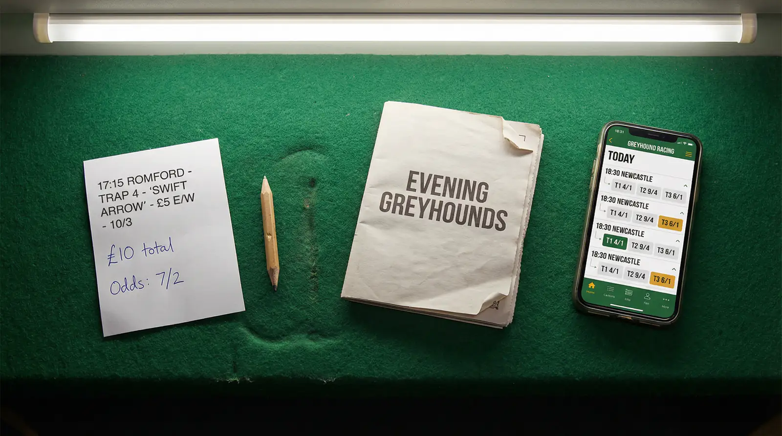 Betting slip for a greyhound each-way bet alongside a smartphone showing live odds at a UK bookmaker